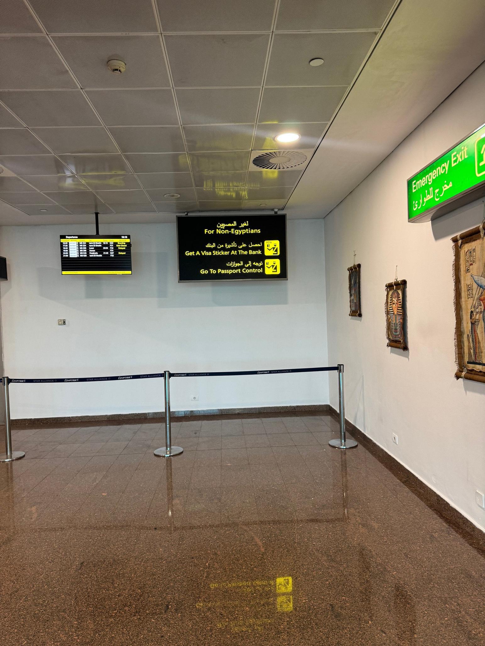 Interior airport guidance sign for non-Egyptians, visa sticker bank, and passport control