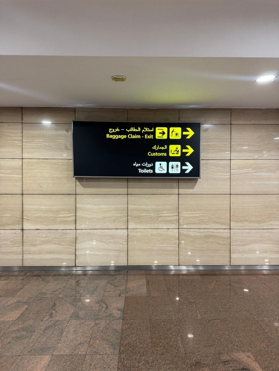 Airport wayfinding sign for baggage claim, customs, and toilets